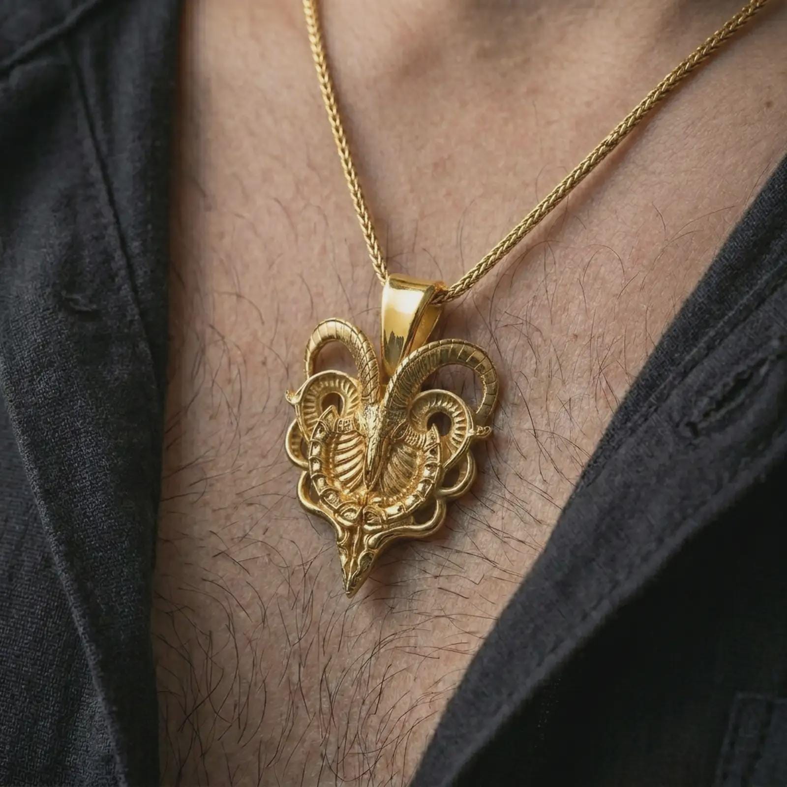 Gold plated biomechanical ram skull pendant necklace worn on the chest, premium lifestyle jewelry photo with the mechanical ram skull pendant centered on a spiga chain.