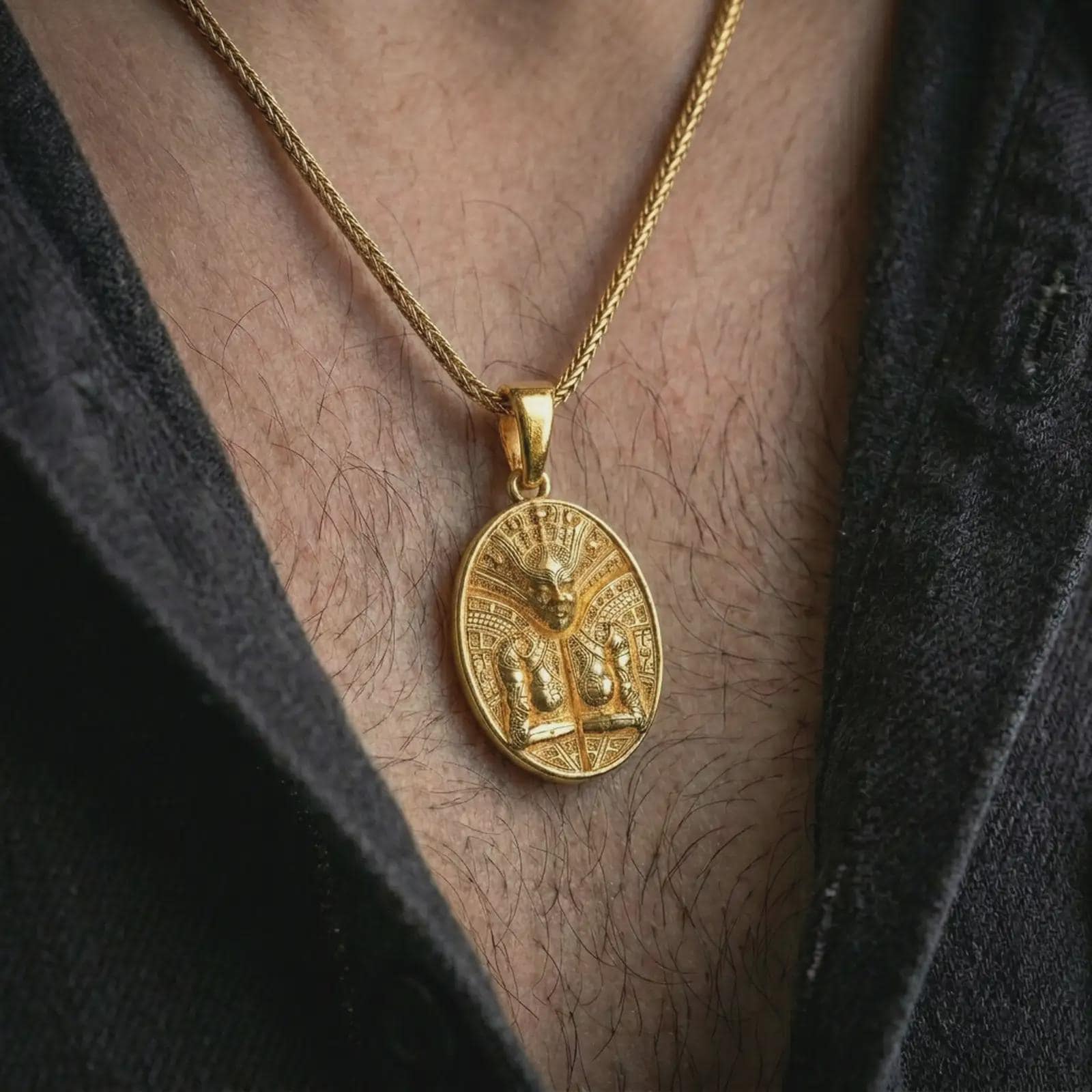 A gold plated Aztec mask pendant is worn on the neck in a close-up lifestyle shot, styled as a meaningful ancient warrior amulet for men.