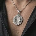 Load image into Gallery viewer, Polished silver Pisces zodiac pendant necklace worn on the chest, masculine lifestyle shot highlighting the twin fish design, sun detail, and bright silver finish.
