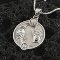 Load image into Gallery viewer, Polished silver Pisces zodiac pendant necklace on textured volcanic rock, centered macro jewelry photo with detailed twin fish relief and bright silver highlights.
