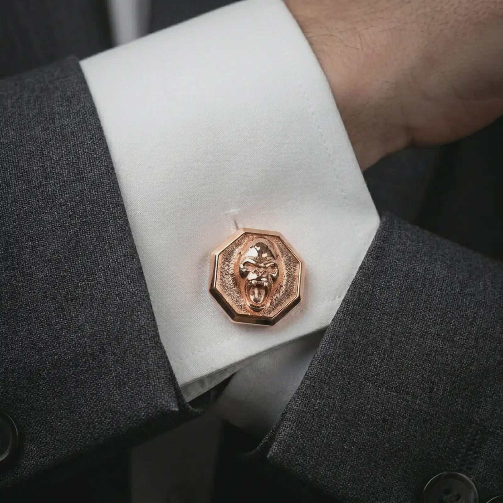 Rose gold plated gorilla cufflinks worn on a suit cuff, close-up lifestyle shot featuring the powerful ape design with warm rose gold tones.