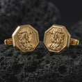 Load image into Gallery viewer, Gold plated Medusa cufflinks sit on textured volcanic rock in a dramatic studio macro shot, highlighting the bold Gorgon motif and formal accessory design.
