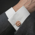 Load image into Gallery viewer, A rose gold plated scarab cufflink is worn on a shirt cuff in a close-up lifestyle composition, highlighting its octagon frame and scarab motif.
