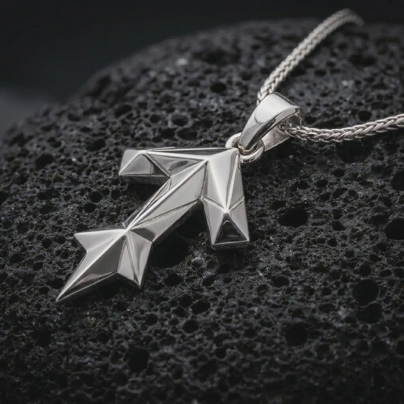 A polished silver Tyr rune pendant is displayed on black volcanic rock in a premium macro studio close-up with sharp angular lines and clean symbolic detail.