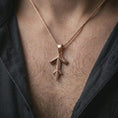 Load image into Gallery viewer, A rose gold plated Tyr rune pendant is worn on the neck in a close-up lifestyle composition, highlighting its geometric rune form and symbolic Norse character.
