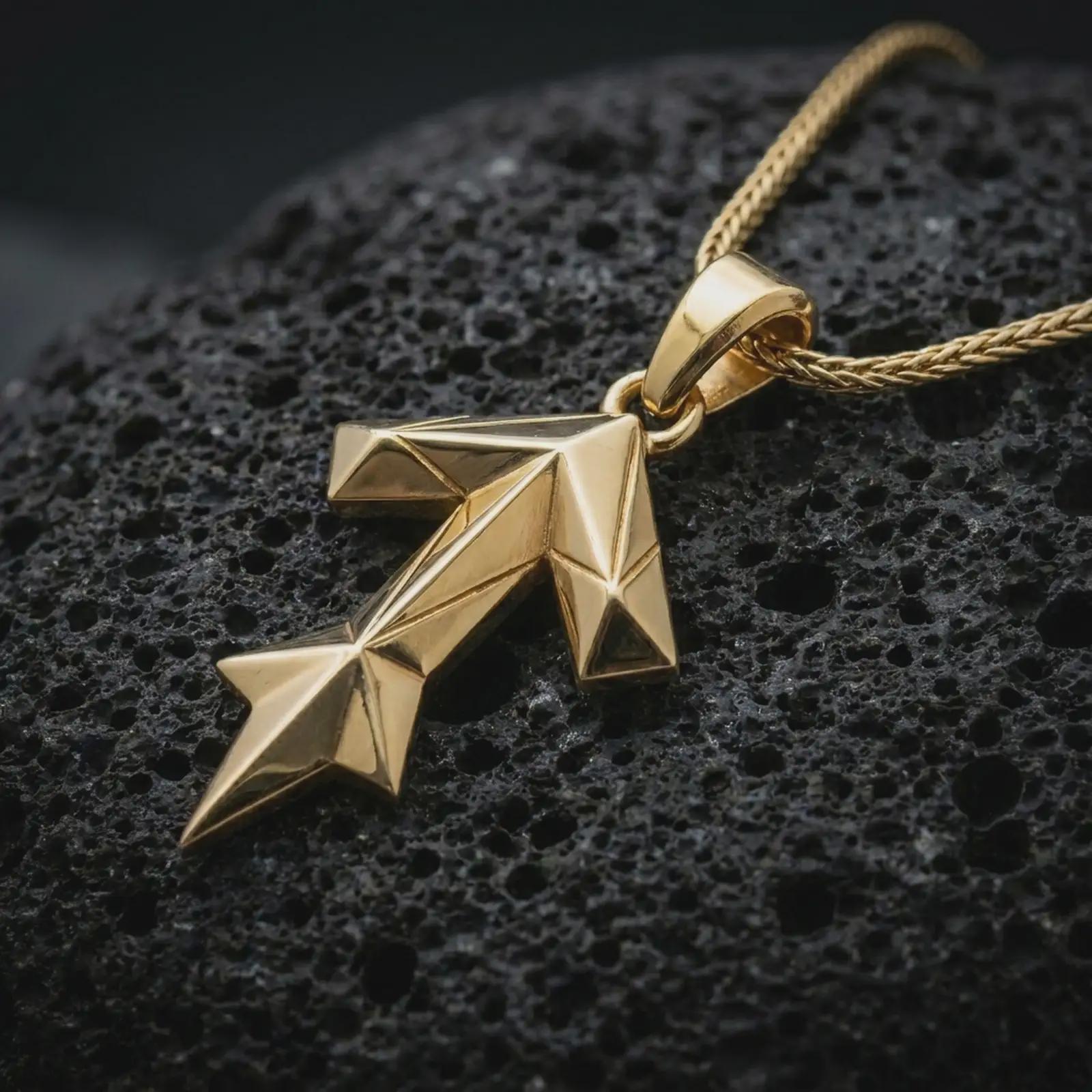 A gold plated Tyr rune pendant lies on textured volcanic rock in a dramatic studio macro shot, highlighting the Teiwaz symbol and Viking-inspired form.
