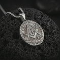 Load image into Gallery viewer, Polished silver Masonic square and compass pendant necklace on textured volcanic rock, centered macro jewelry photo with detailed Freemason engraving and bright silver highlights.
