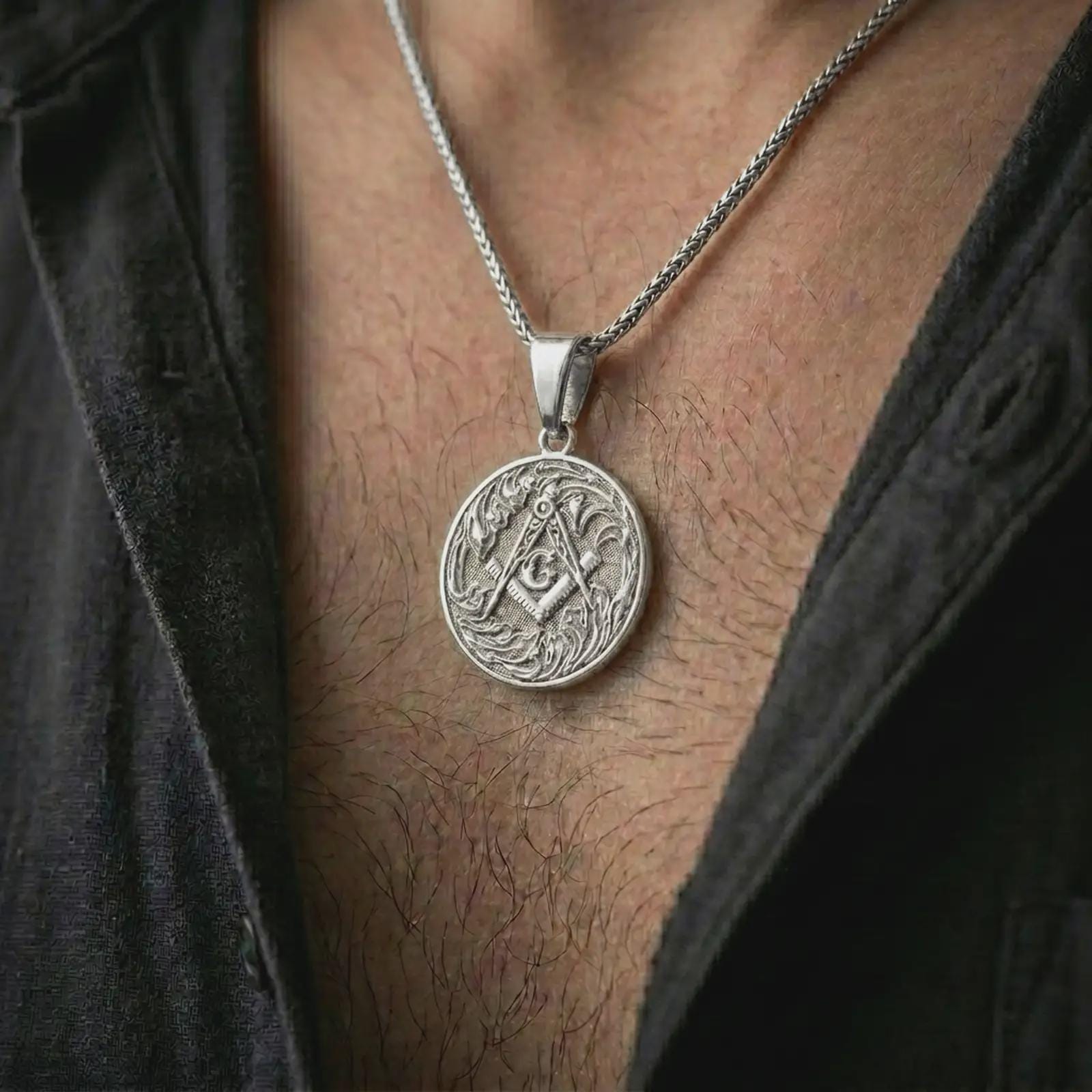 Polished silver Masonic square and compass pendant necklace worn on the chest, masculine lifestyle shot highlighting the bright silver finish, engraved compass, and square symbol.