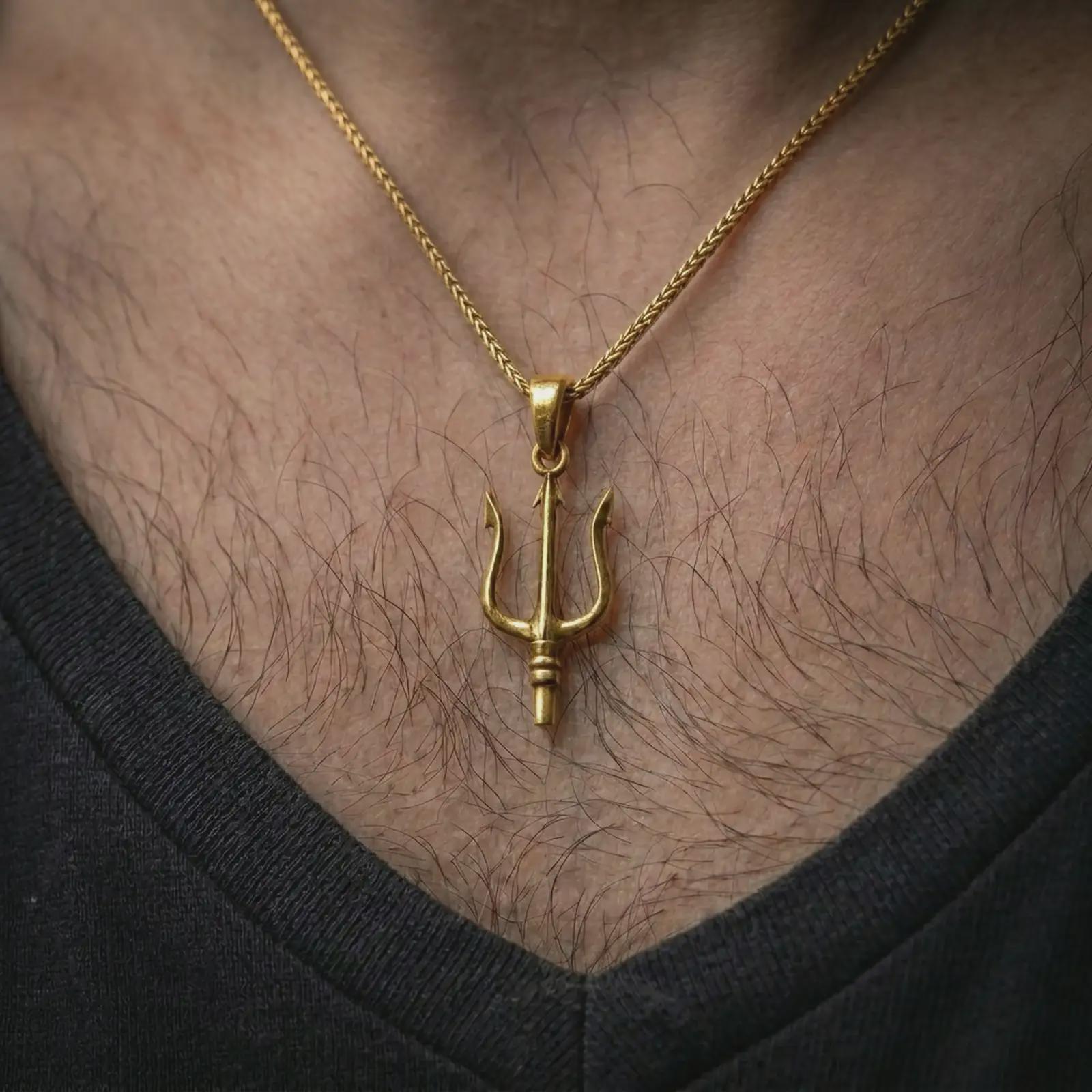 Gold plated Poseidon trident pendant necklace worn on the chest, premium lifestyle jewelry photo with the sea god trident pendant centered on a spiga chain.
