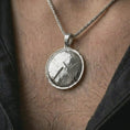 Load image into Gallery viewer, Polished silver Spartan shield pendant necklace worn on the chest, masculine lifestyle shot highlighting the bright silver finish, cracked shield texture, and raised lambda detail.
