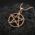 Load image into Gallery viewer, Rose gold plated thorn pentagram pendant necklace on textured volcanic rock, detailed macro product shot with soft warm reflections and dark symbolic styling.
