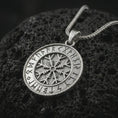 Load image into Gallery viewer, Polished silver Vegvisir Viking rune pendant necklace on textured volcanic rock, centered macro jewelry photo with detailed compass relief and bright silver highlights.
