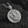 Load image into Gallery viewer, Polished silver Lion of Judah pendant necklace on textured volcanic rock, centered macro jewelry photo with detailed lion relief and bright silver highlights.
