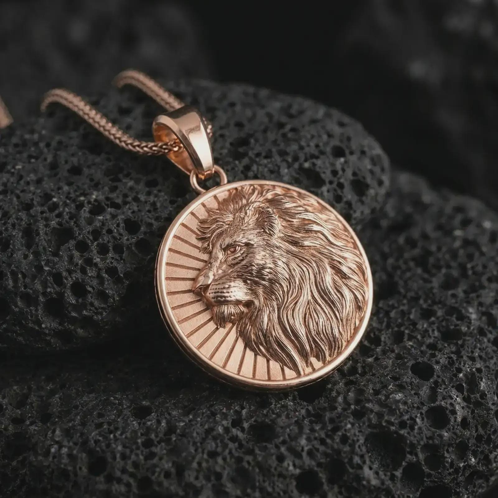 Rose gold plated Lion of Judah pendant necklace on textured volcanic rock, detailed macro product shot with soft warm reflections and powerful messianic lion symbolism.