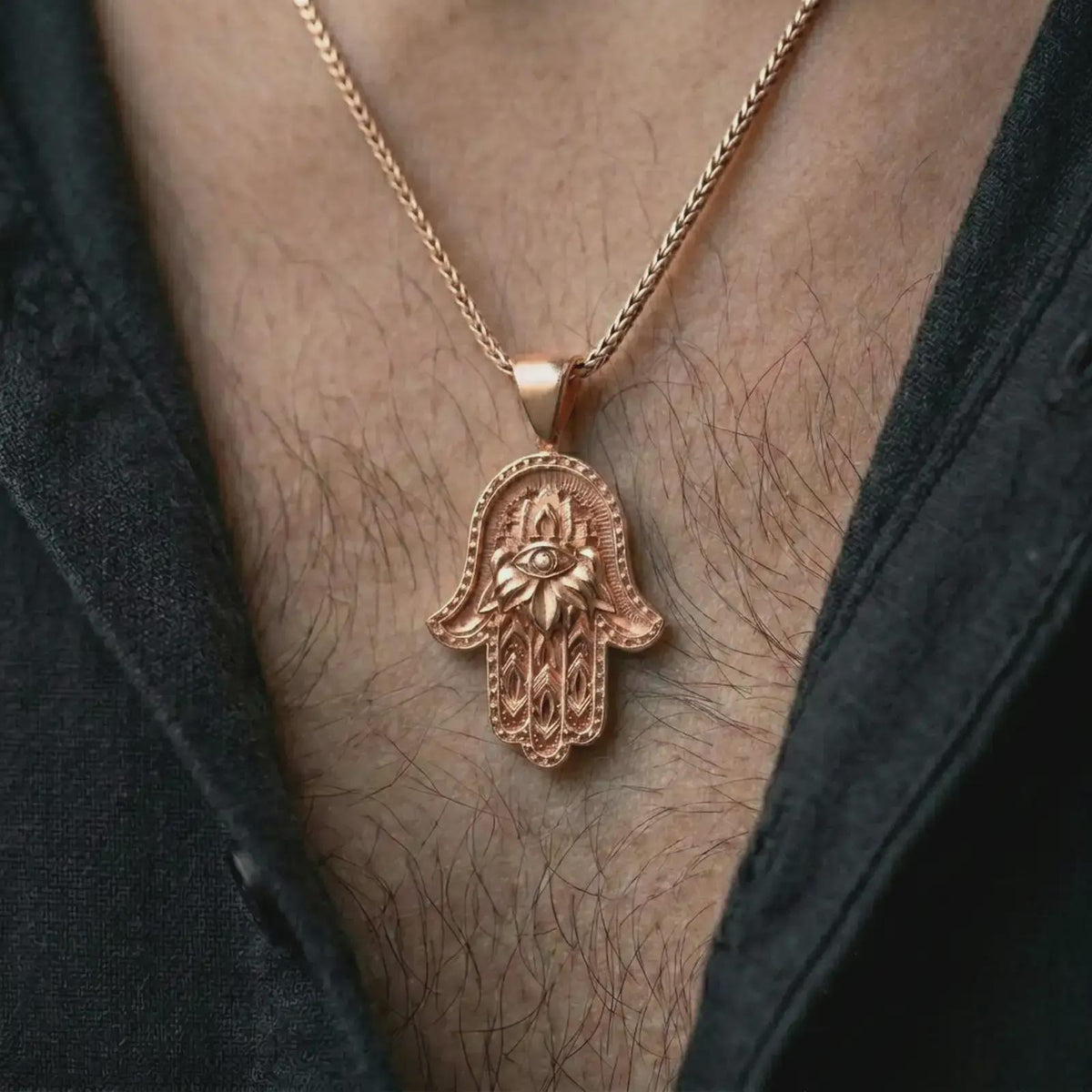 Rose gold plated hamsa hand pendant necklace worn on the chest, close-up lifestyle shot featuring the protective hamsa hand design with warm rose gold tones.