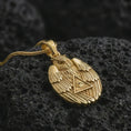 Load image into Gallery viewer, Gold plated owl all-seeing eye pendant necklace on textured volcanic rock, premium close-up studio composition emphasizing the wise owl figure, triangle eye symbol, and mystical amulet design.
