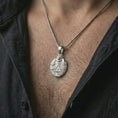 Load image into Gallery viewer, Polished silver owl all-seeing eye pendant necklace worn on the chest, masculine lifestyle shot highlighting the bright silver finish, feathered wings, and triangle eye detail.
