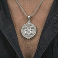 Load image into Gallery viewer, Polished silver Gemini zodiac pendant necklace worn on the chest, masculine lifestyle shot highlighting the twin figures, sun detail, and bright silver finish.
