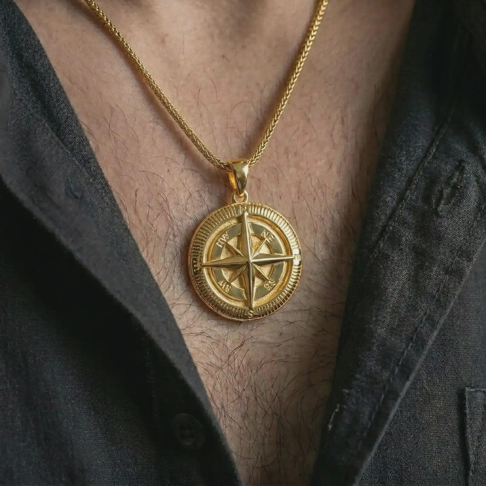 Gold plated compass pendant necklace worn on the chest, premium lifestyle jewelry photo with the explorer compass pendant centered on a spiga chain.