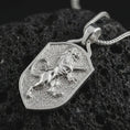 Load image into Gallery viewer, Polished silver heraldic lion shield pendant necklace on textured volcanic rock, centered macro jewelry photo with detailed lion mane, raised paws, and bright silver highlights.
