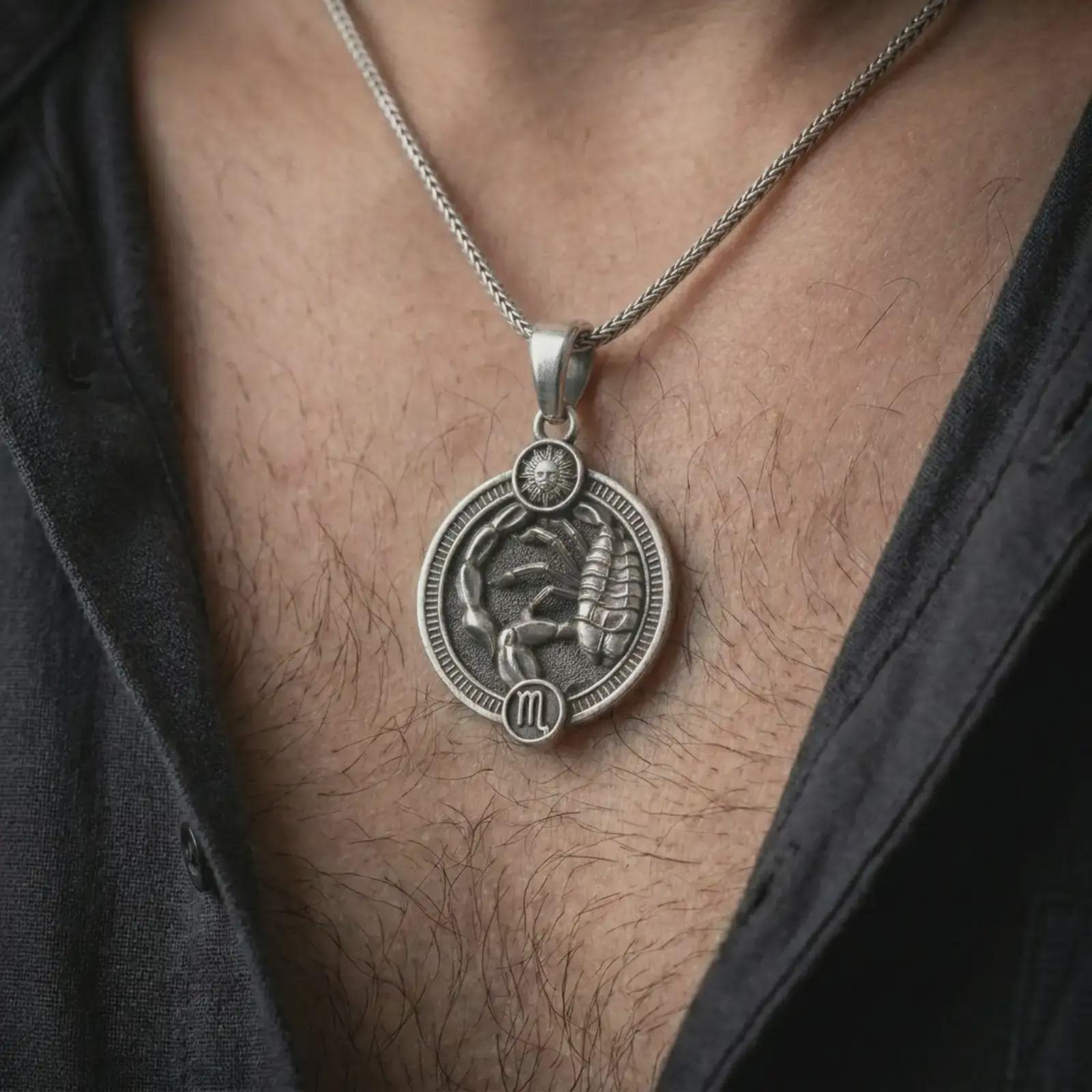 Oxidized Scorpio zodiac pendant necklace worn on the chest, close-up lifestyle jewelry photo showing the scorpion astrology medallion on a spiga chain with dark clothing.