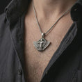 Load image into Gallery viewer, An oxidized Faravahar pendant is worn on the neck in a close-up lifestyle shot, centered on the chest as a meaningful Persian heritage necklace.
