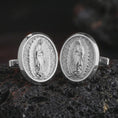 Load image into Gallery viewer, Polished silver Our Lady of Guadalupe cufflinks are displayed on black volcanic rock in a premium macro studio close-up with detailed Catholic devotional artwork.

