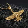 Load image into Gallery viewer, Gold plated Faravahar pendant necklace on textured volcanic rock, premium close-up studio composition emphasizing the ancient Persian wings, central figure, and spiritual amulet design.
