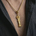 Load image into Gallery viewer, A gold plated demon slayer sword pendant is worn on the neck in a close-up lifestyle shot, styled as a powerful gaming-inspired gift for men.
