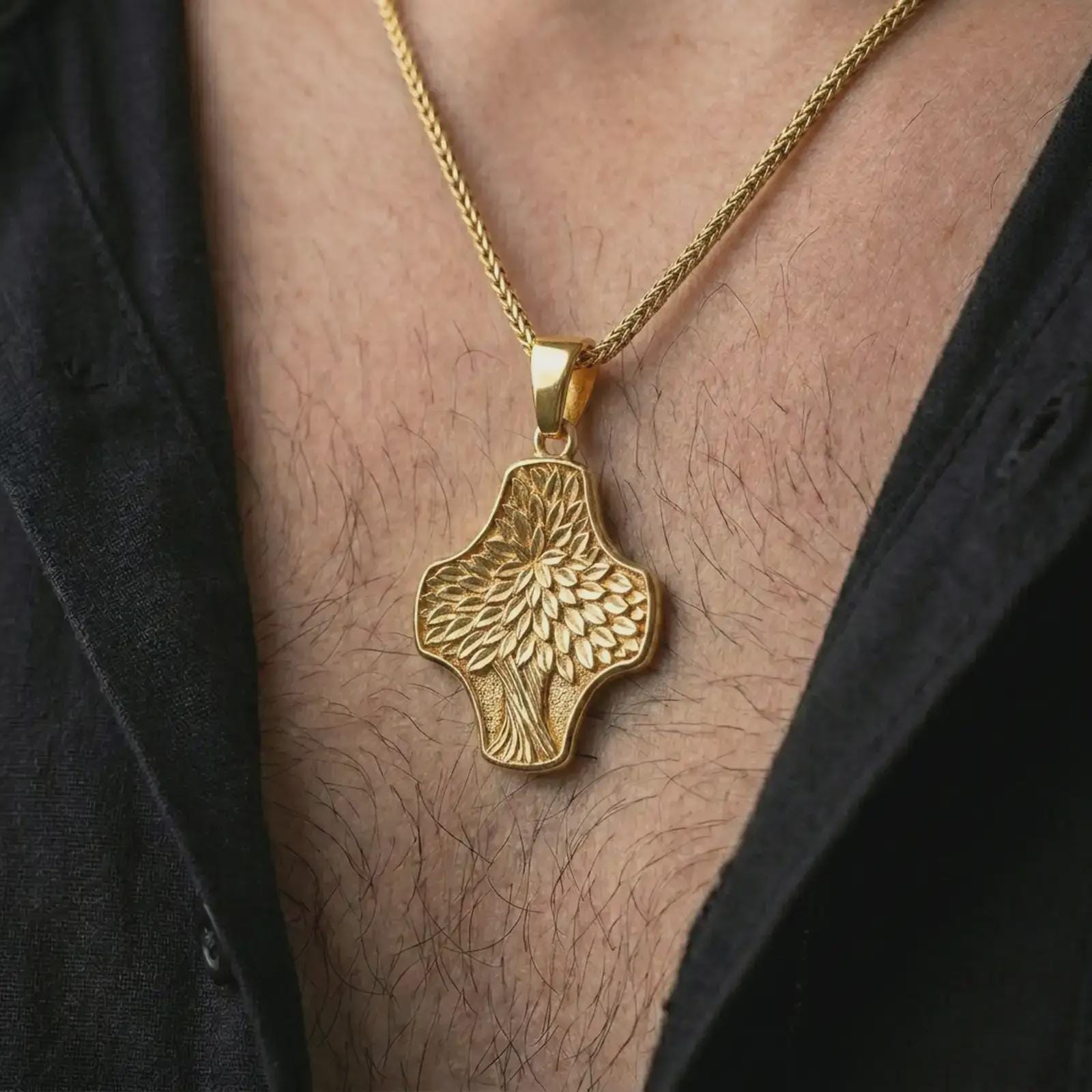 A gold plated Tree of Life cross pendant is worn on the neck in a close-up lifestyle shot, styled as a symbolic spiritual gift for men and women.