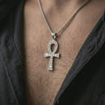 Load image into Gallery viewer, Polished silver ankh cross pendant necklace worn on the chest, masculine lifestyle shot highlighting the bright silver finish, key of life silhouette, and engraved hieroglyphic details.
