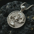 Load image into Gallery viewer, Polished silver koi fish lotus pendant necklace on textured volcanic rock, centered macro jewelry photo with detailed fish scales, flowing fins, and bright silver highlights.
