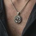 Load image into Gallery viewer, Oxidized koi fish lotus pendant necklace worn on the chest, close-up lifestyle jewelry photo showing the yin yang fish medallion on a spiga chain with dark clothing.

