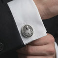 Load image into Gallery viewer, An oxidized Saint Francis cufflink is worn on a white shirt cuff in a close-up lifestyle shot, styled with a dark suit as a meaningful Catholic accessory.
