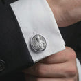 Load image into Gallery viewer, A polished silver Saint Francis cufflink is worn on a shirt cuff in a premium close-up lifestyle image, showing the saint relief clearly.
