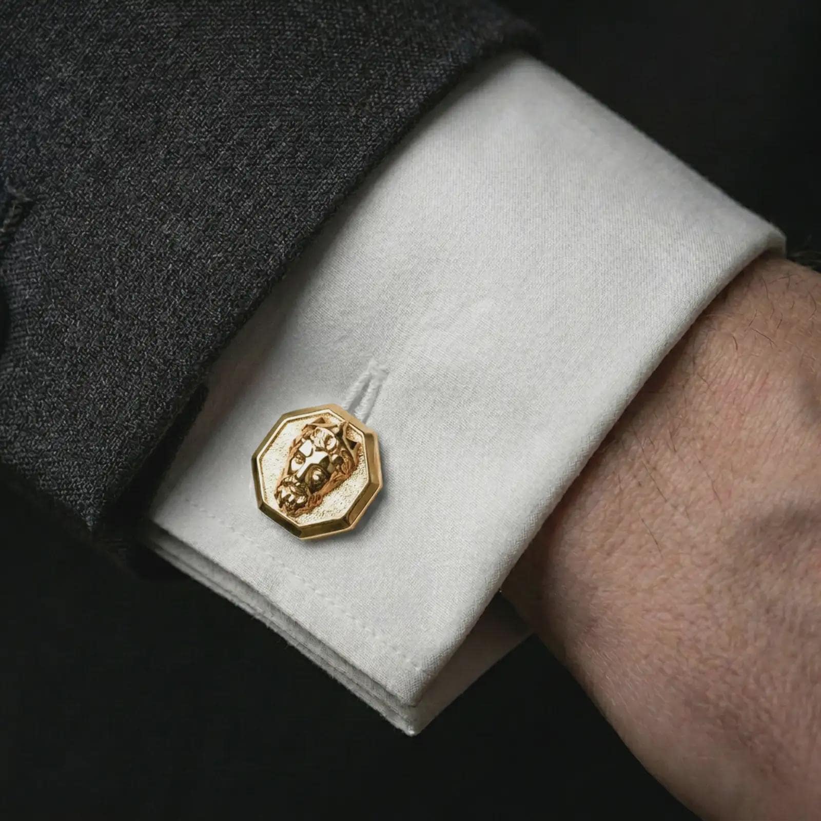 A gold plated Zeus cufflink is worn on a white cuff in a close-up lifestyle shot, styled as a meaningful mythology gift for men.