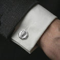 Load image into Gallery viewer, A polished silver Zeus cufflink is worn on a shirt cuff in a premium close-up lifestyle image, showing the sculpted Greek god face clearly.
