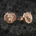 Load image into Gallery viewer, Rose gold plated bull head cufflinks are photographed on porous volcanic rock in a close-up studio composition with refined luxury lighting and strong bull features.
