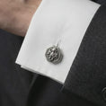 Load image into Gallery viewer, An oxidized octopus cufflink is worn on a white shirt cuff in a close-up lifestyle shot, styled with a dark suit for a bold nautical look.

