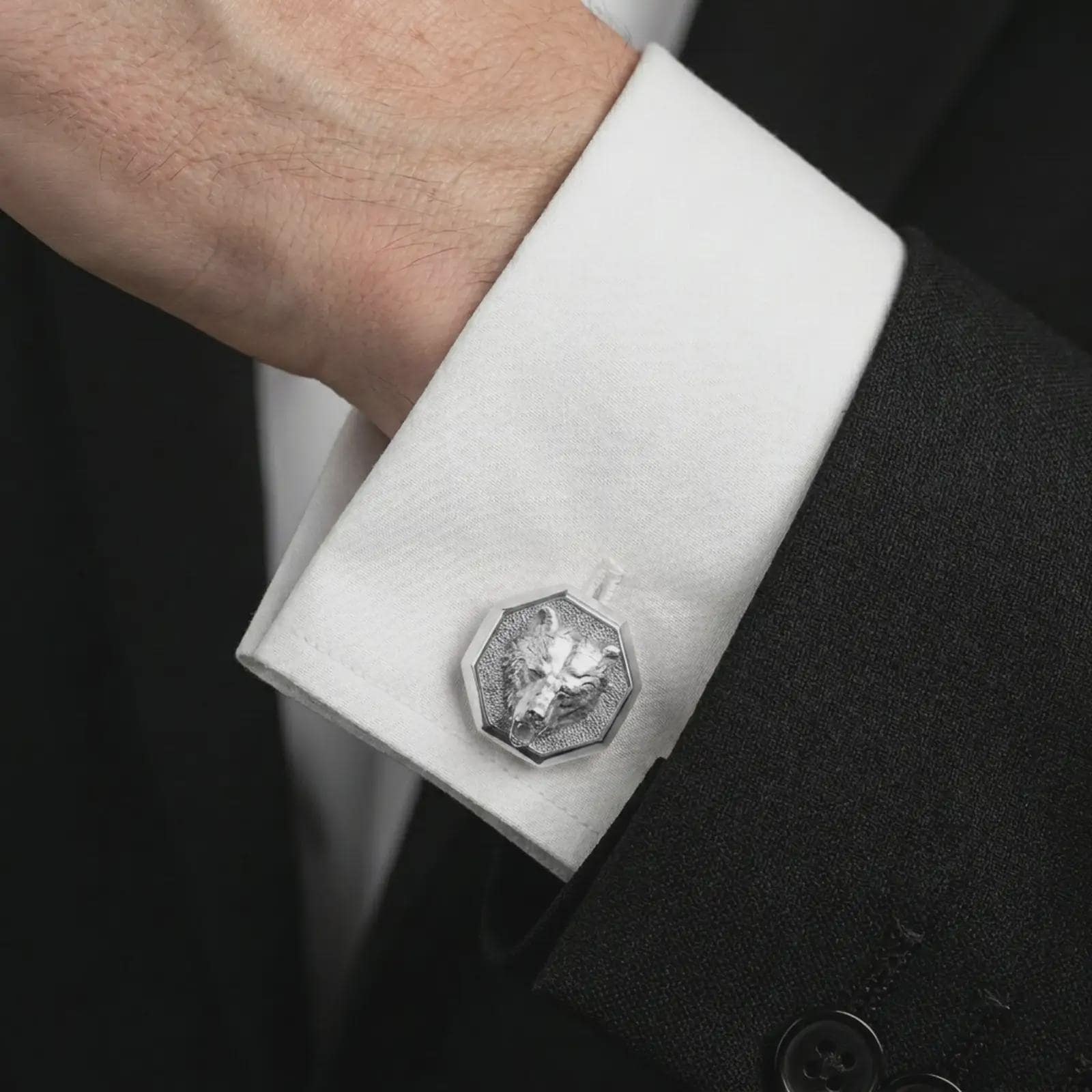 A polished silver bear head cufflink is worn on a shirt cuff in a premium close-up lifestyle image, showing the sculpted bear face clearly.