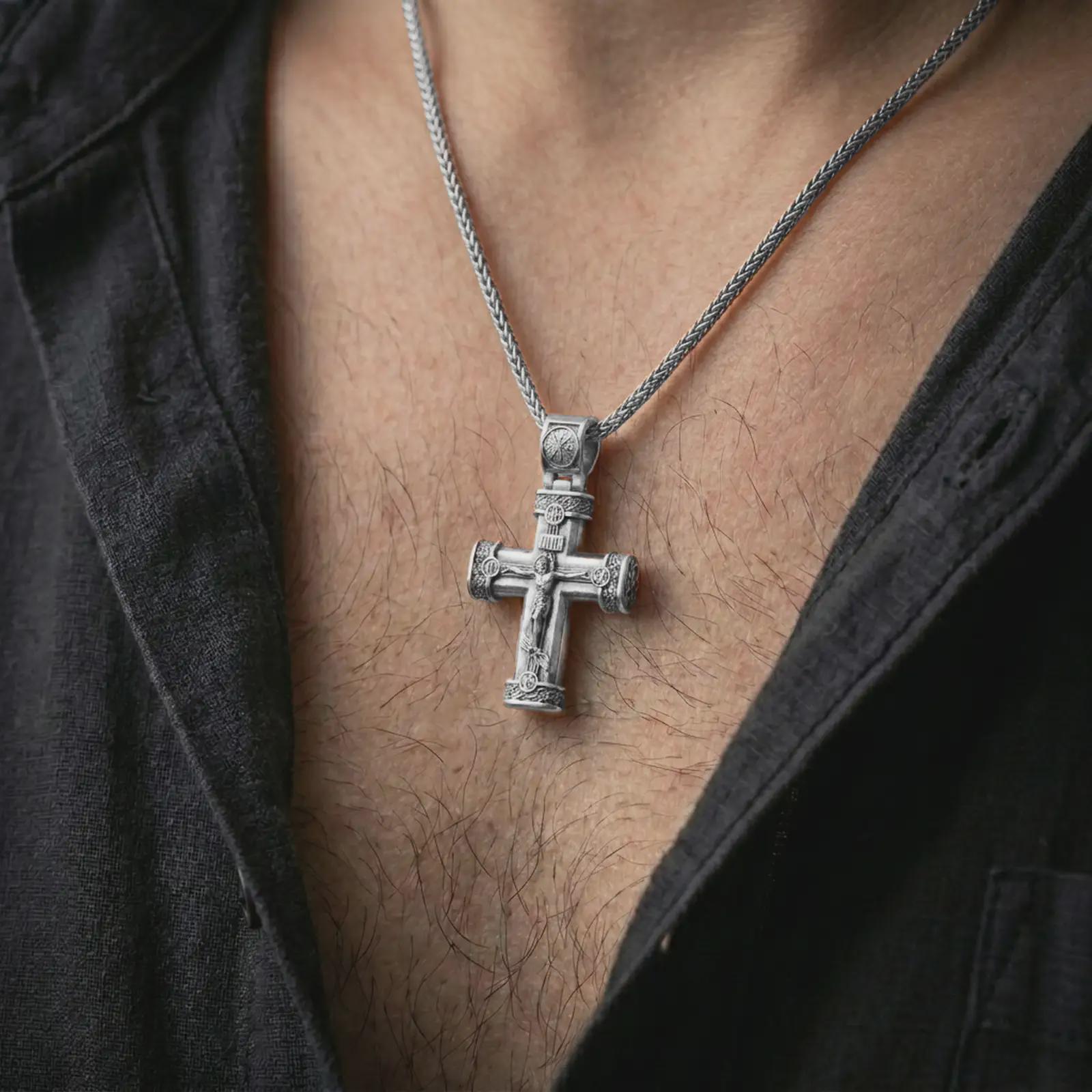 Polished silver crucifix cross pendant necklace worn on the chest, masculine lifestyle shot highlighting the bright silver finish, sculpted Christ figure, and detailed cross accents.