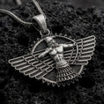 Load image into Gallery viewer, An oxidized Faravahar pendant rests on dark volcanic rock in a macro studio close-up, showing a detailed winged Persian symbol with a central figure.

