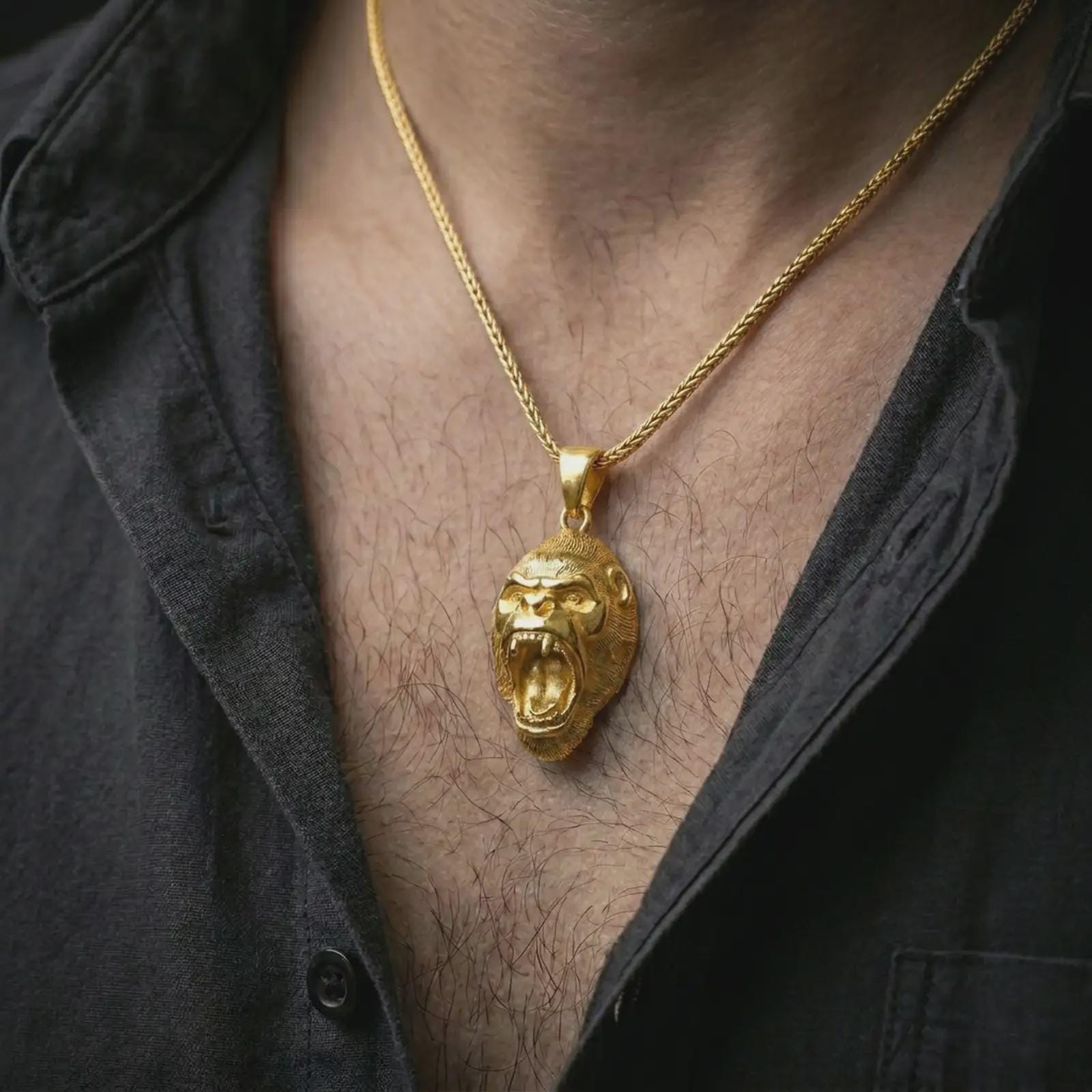 A gold plated gorilla pendant is worn on the neck in a close-up lifestyle shot, styled as a powerful strength symbol gift for men.