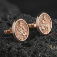 Load image into Gallery viewer, Rose gold plated Blessed Mother cufflinks are photographed on porous volcanic rock in a close-up studio composition with refined luxury lighting and religious detail.
