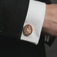 Load image into Gallery viewer, A rose gold plated Blessed Mother cufflink is worn on a shirt cuff in a close-up lifestyle composition, highlighting its oval frame and sacred Catholic design.
