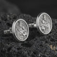 Load image into Gallery viewer, An oxidized Blessed Mother cufflink pair rests on dark volcanic rock in a macro studio close-up, showing the Virgin Mary and Child relief in oval frames.
