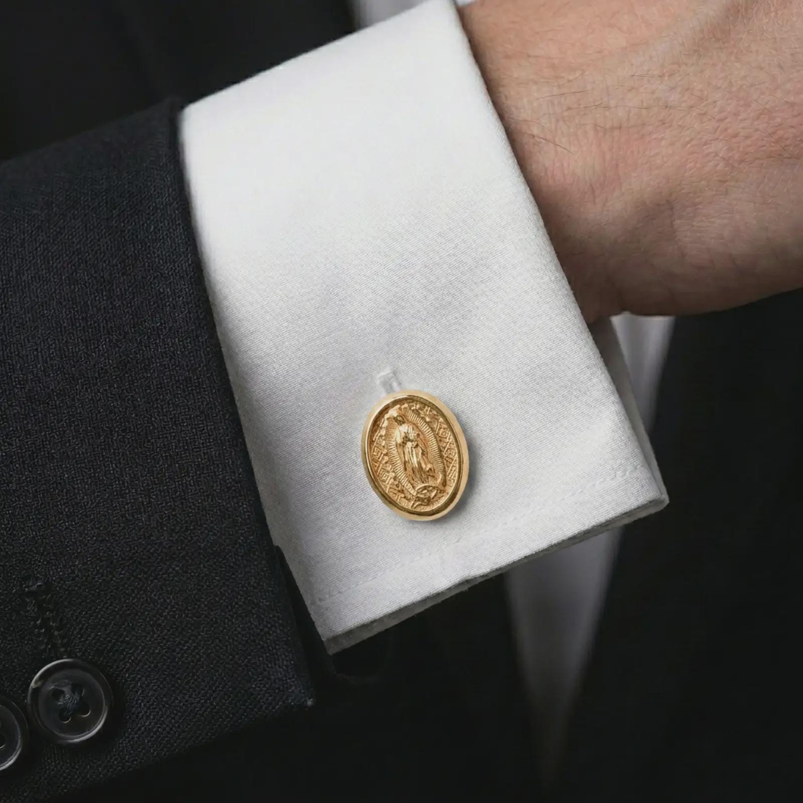 A gold plated Our Lady of Guadalupe cufflink is worn on a white cuff in a close-up lifestyle shot, styled as a thoughtful religious gift for men.