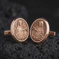 Load image into Gallery viewer, Rose gold plated Mary Magdalene cufflinks are photographed on porous volcanic rock in a close-up studio composition with refined luxury lighting and religious detail.

