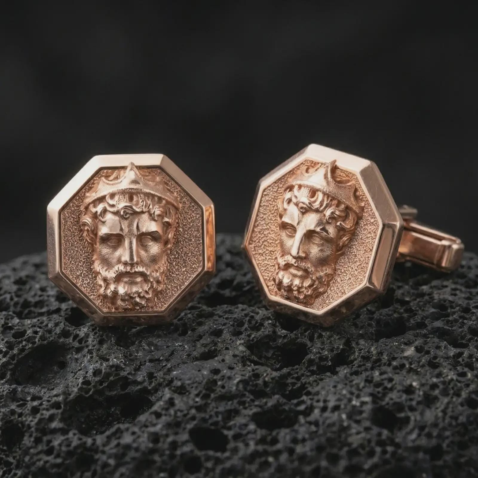 Rose gold plated Zeus cufflinks are photographed on porous volcanic rock in a close-up studio composition with refined luxury lighting and detailed mythological features.