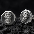 Load image into Gallery viewer, An oxidized Zeus cufflink pair rests on dark volcanic rock in a macro studio close-up, showing a sculpted Greek god portrait inside octagon frames.
